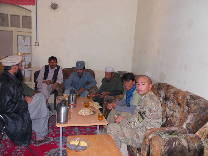 Peter J. Santos seated with Afghan village elders during a meeting